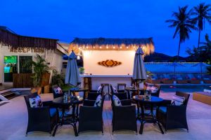 Stílusos vacsora egy elegáns kültéri étteremben, kényelmes ülőhelyekkel, trópusi dekorációval és hívogató hangulattal, ideális a pezsgő Bophut életstílus élvezetéhez.