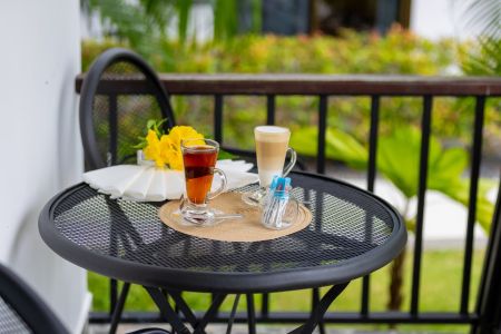 Morning coffee and iced tea on the bistro table of a Garden Villa balcony.